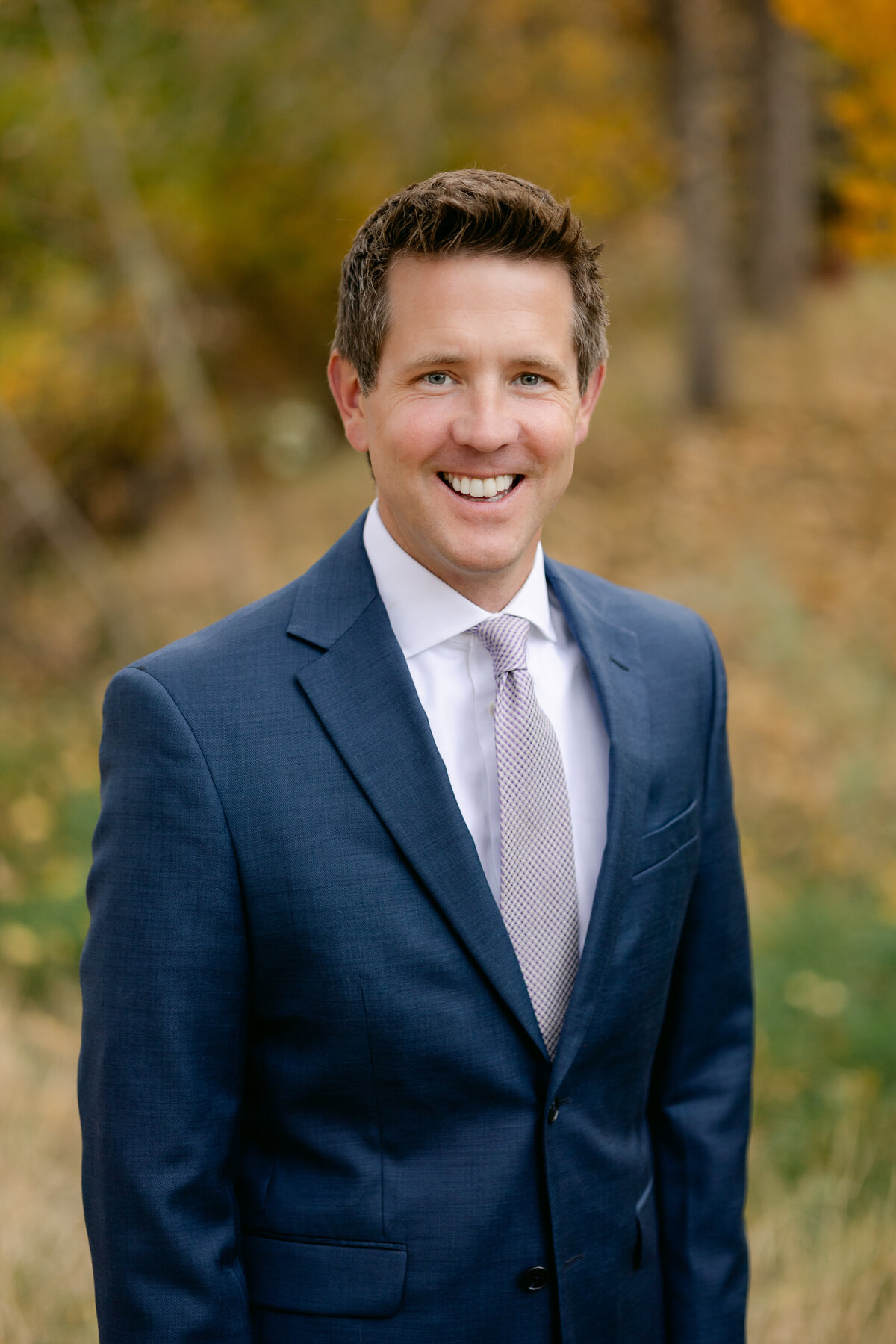 A banker from First National Bank of Omaha stands for a headshot during a fall session in Loveland, Colorado.