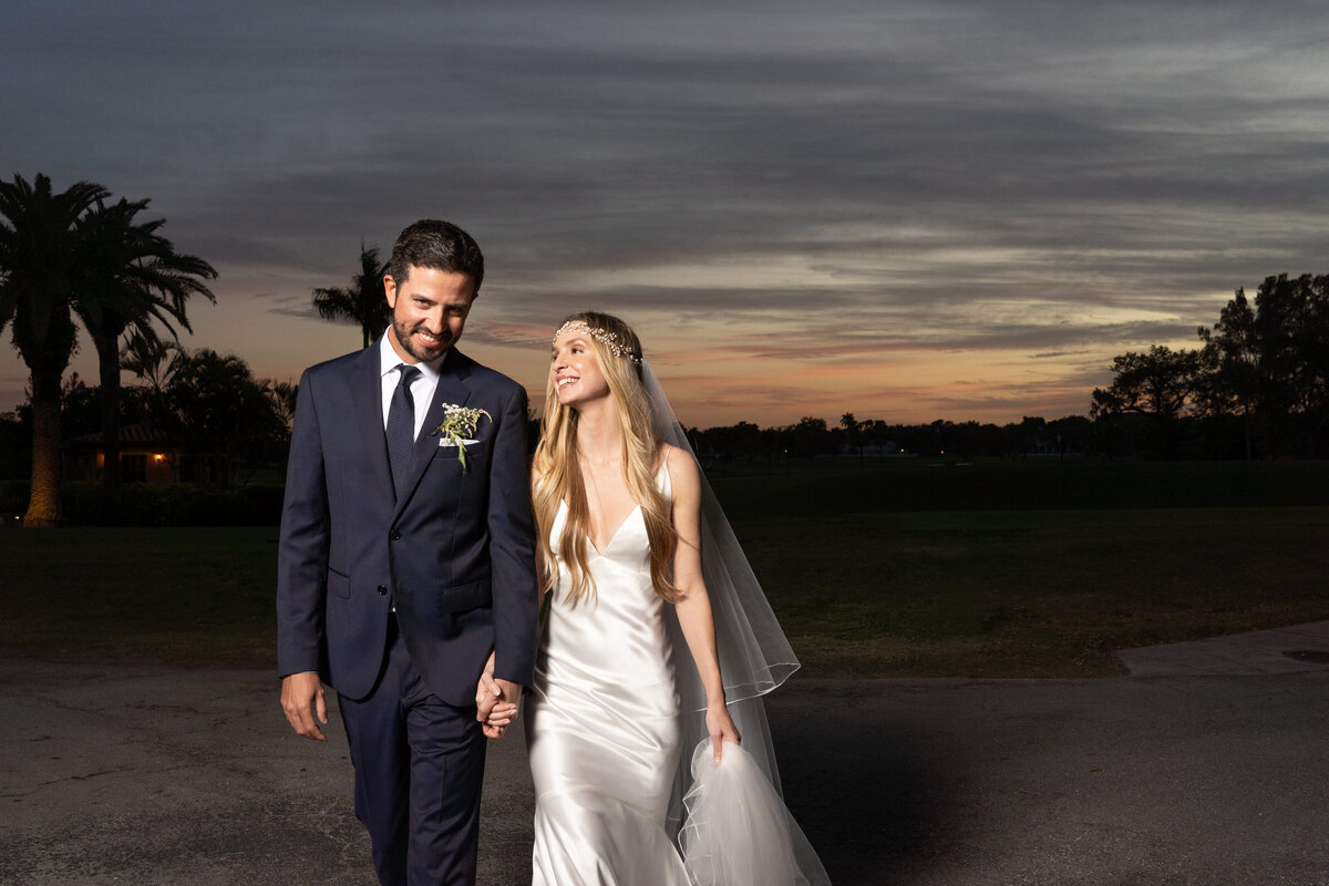 A bride and groom share a peaceful walk at sunset, captured beautifully by Rodrigo Varela Photography.