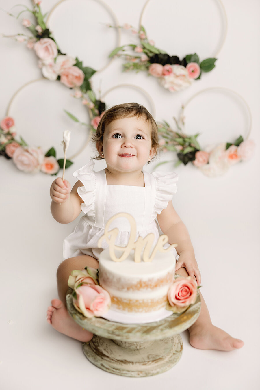 Fort Collins baby girl celebrating first birthday with her cake