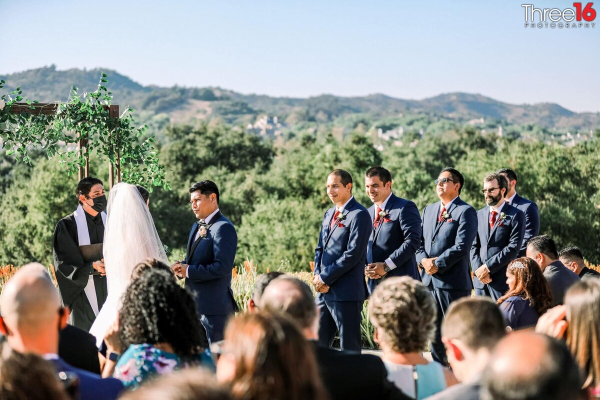Groomsmen look on as the Bride and Groom take their vows