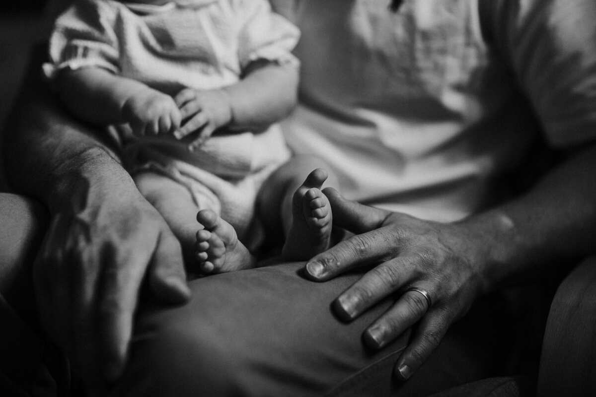 Baby toes with dad's hands