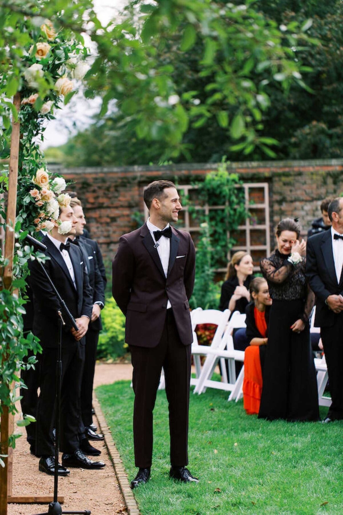 Groom waits at the altar before the ceremony for a luxury Chicago outdoor garden wedding.
