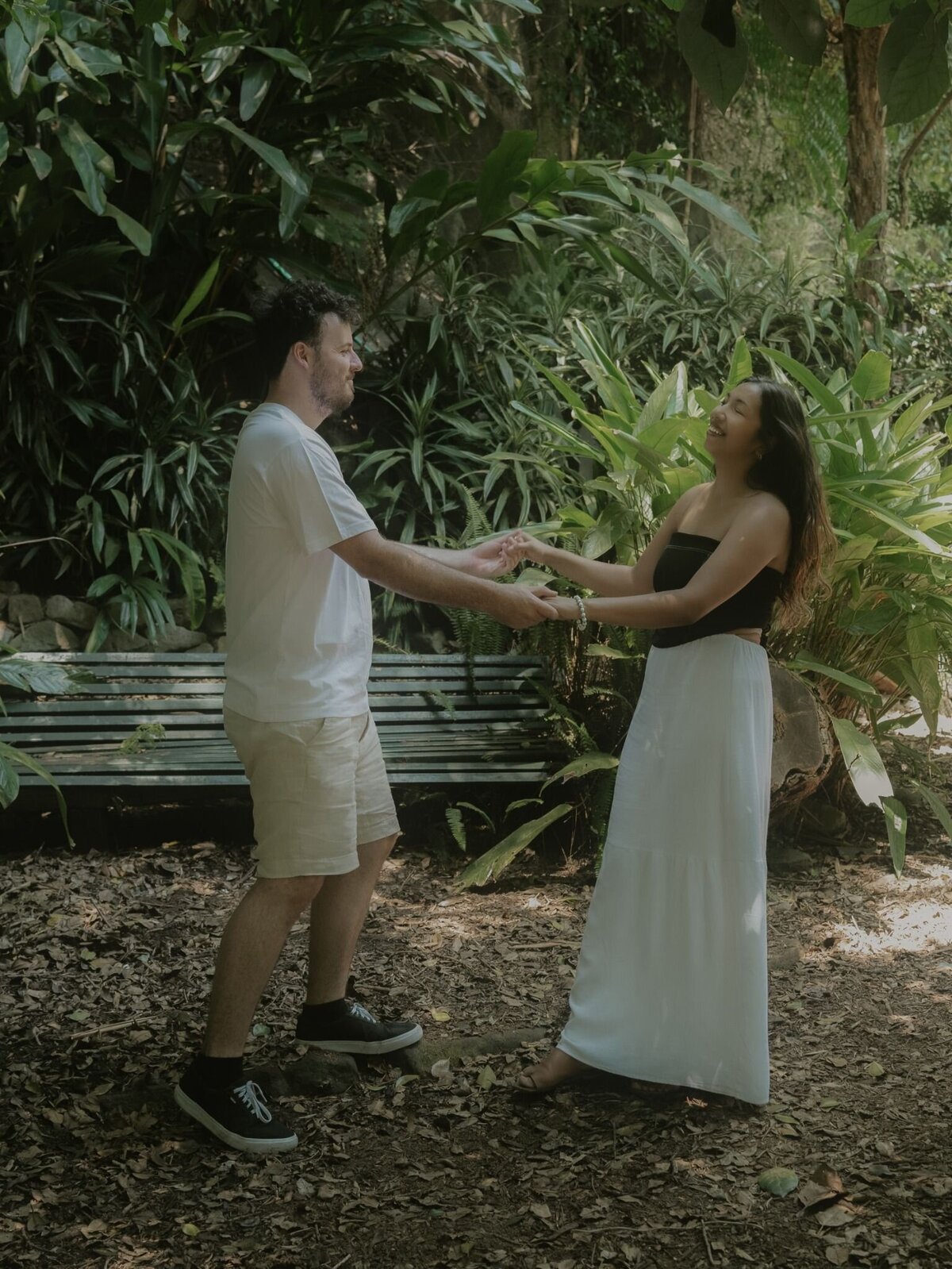 Candid engagement photography of a couple holding hands and laughing in Sydney’s Wendy’s Secret Garden.