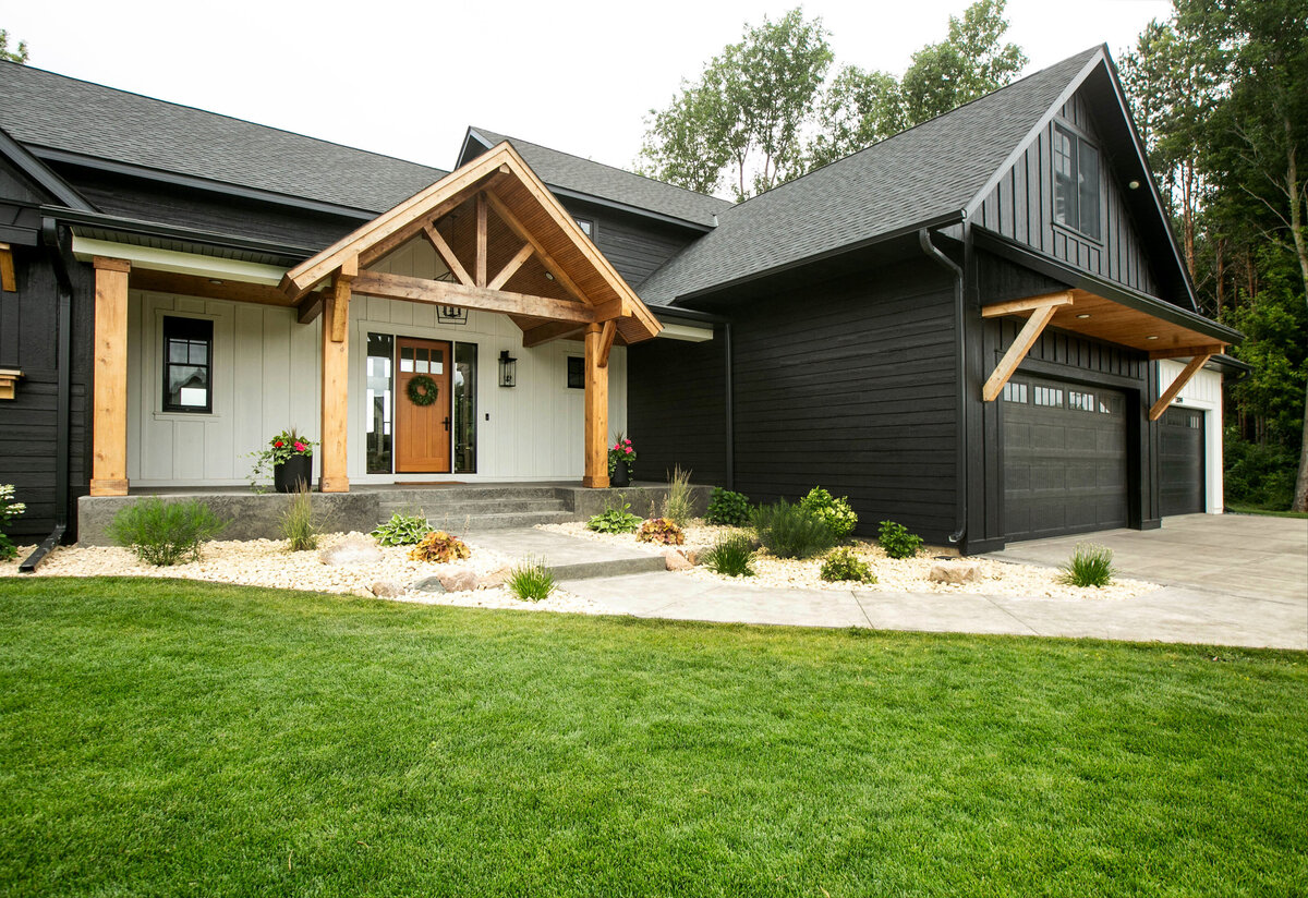 Exterior view of custom home in Otsego, Minnesota with modern wood details and front porch built by Cornerstone Custom Builds