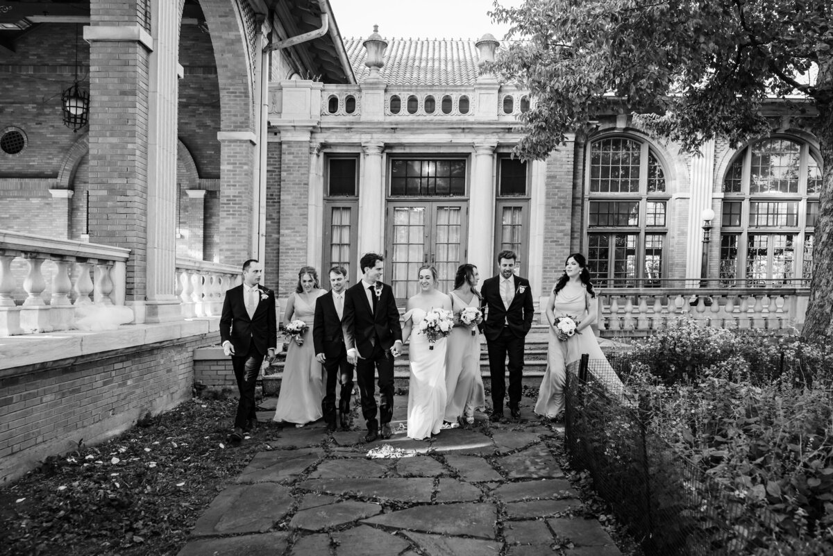 wedding party walks in front of an old mansion in Chicago