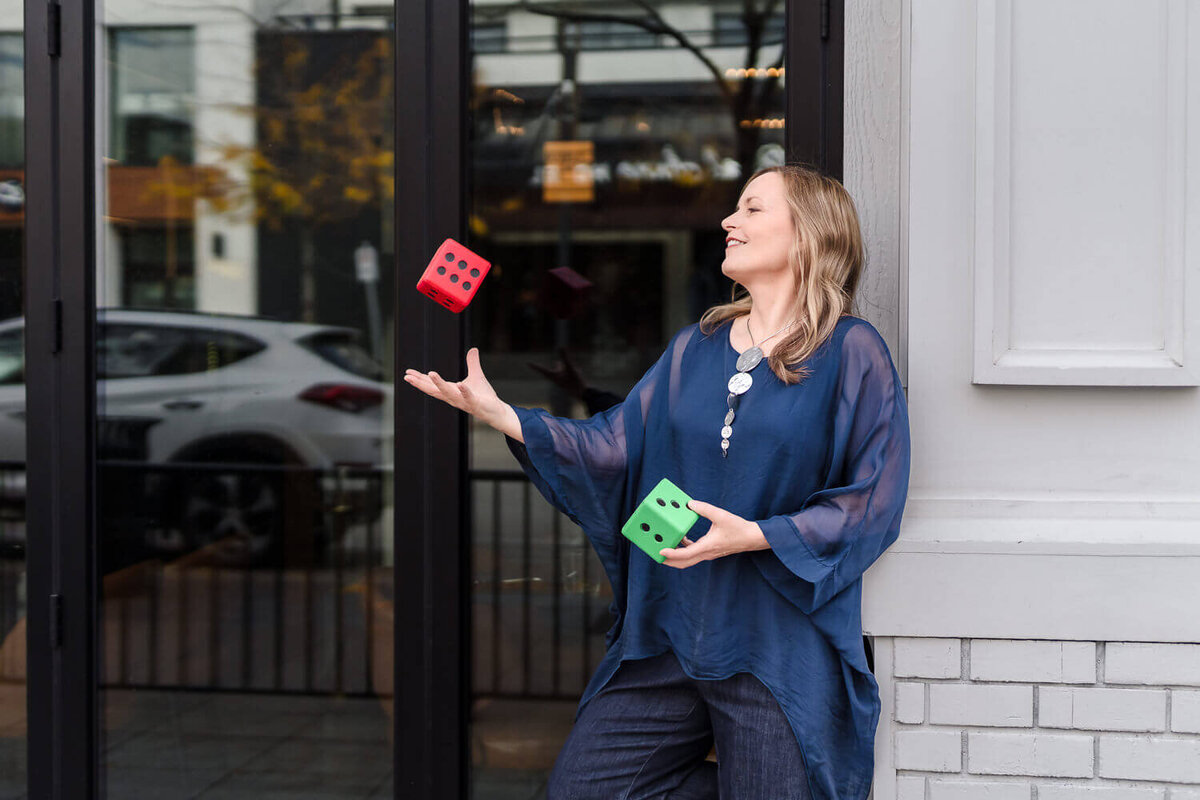 Playful business owner juggling dice in front of downtown Kelowna restaurant