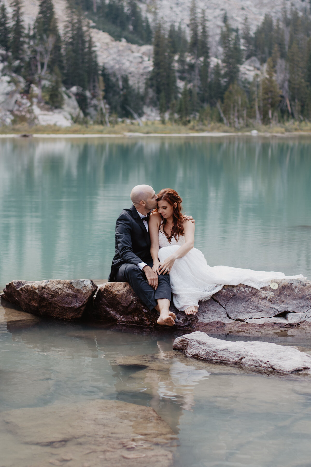 Jackson Hole Photographers capture groom kissing bride's hair after Grand Teton elopement