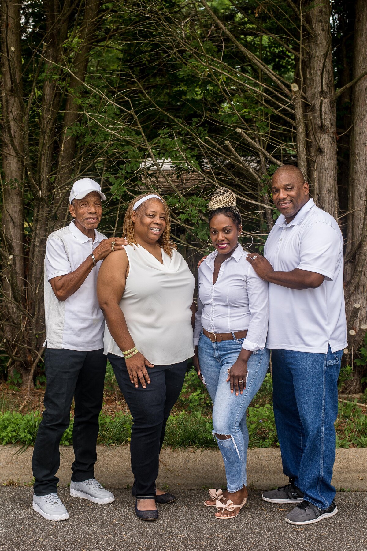 a family wearing matching white shirts smiles at the camera