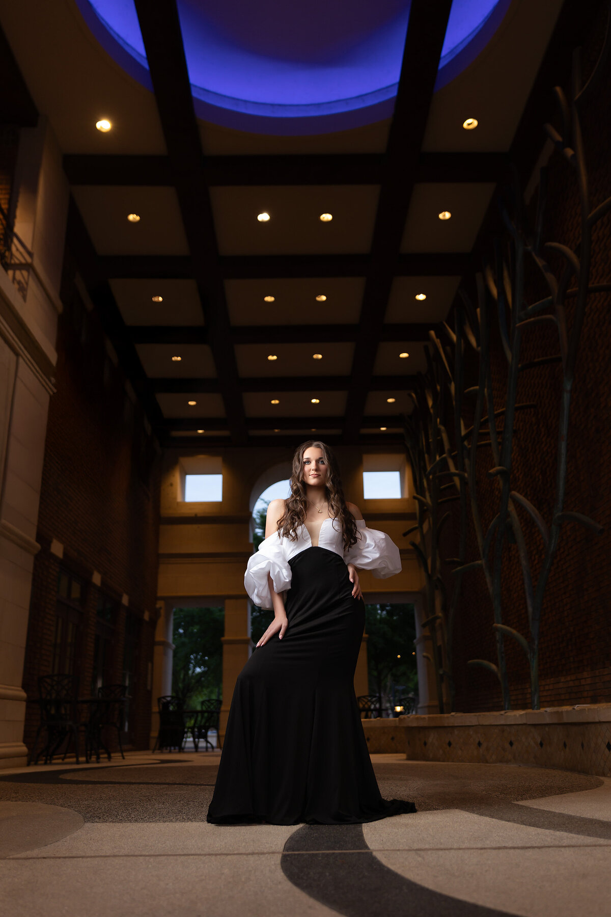 Senior girl posing in a formal black and white gown at a luxury location by Dallas senior photographer.