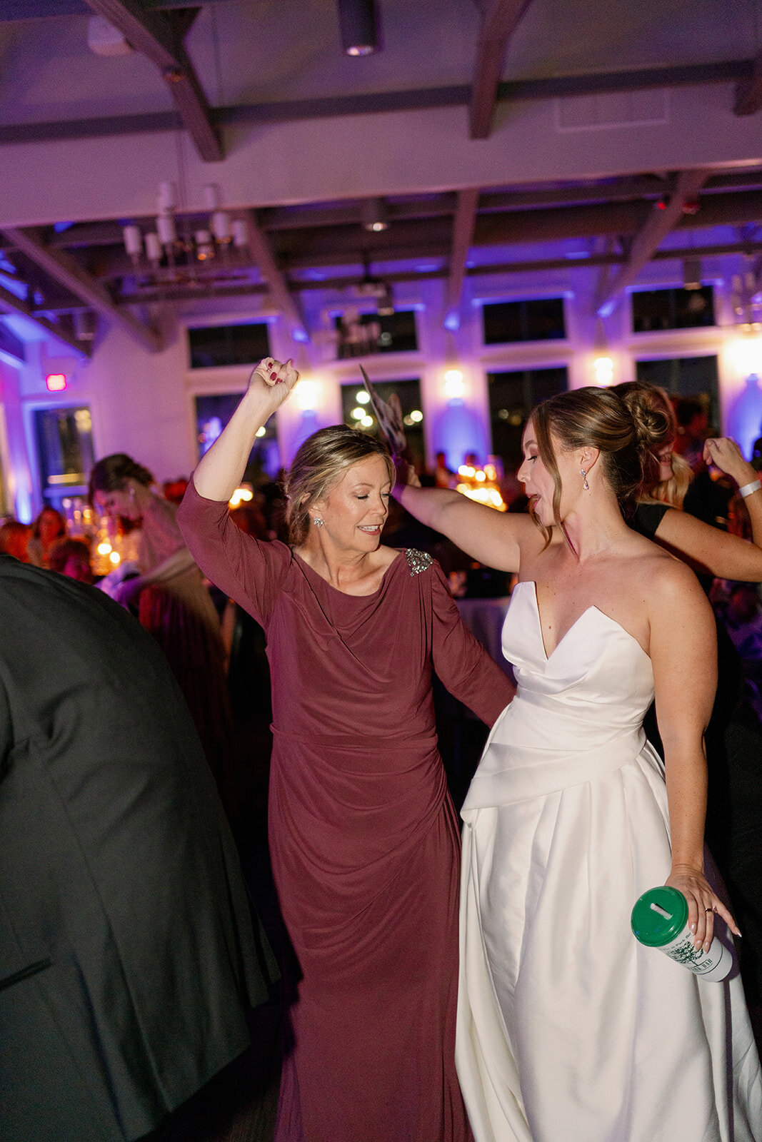 Wedding dance floor photos at Boatwerks in Holland Michigan with colorful lights and fun candid moments.