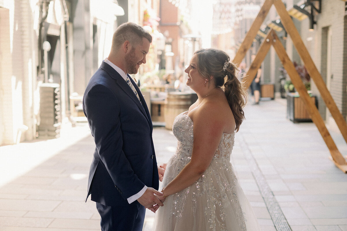 Bride and groom in front of their triangle arches on their wedding day in the Dairy Block in Colorado.