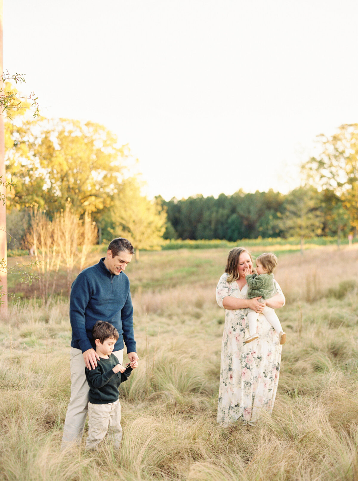 Family plays in the art museum fields for a fall photo session. Image by Raleigh maternity photographer A.J. Dunlap Photography.