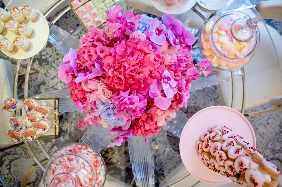 Pink flower centrepiece on a beautiful round dessert table