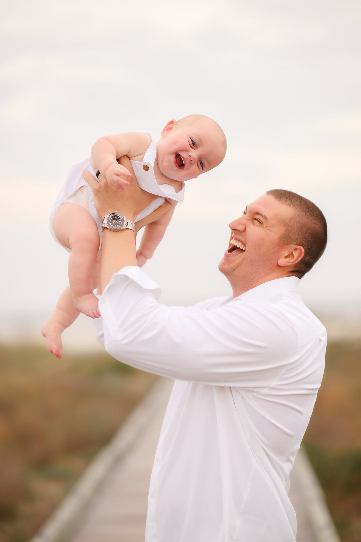 Father plays with this infant during Family Photos on Isle of Palms. 