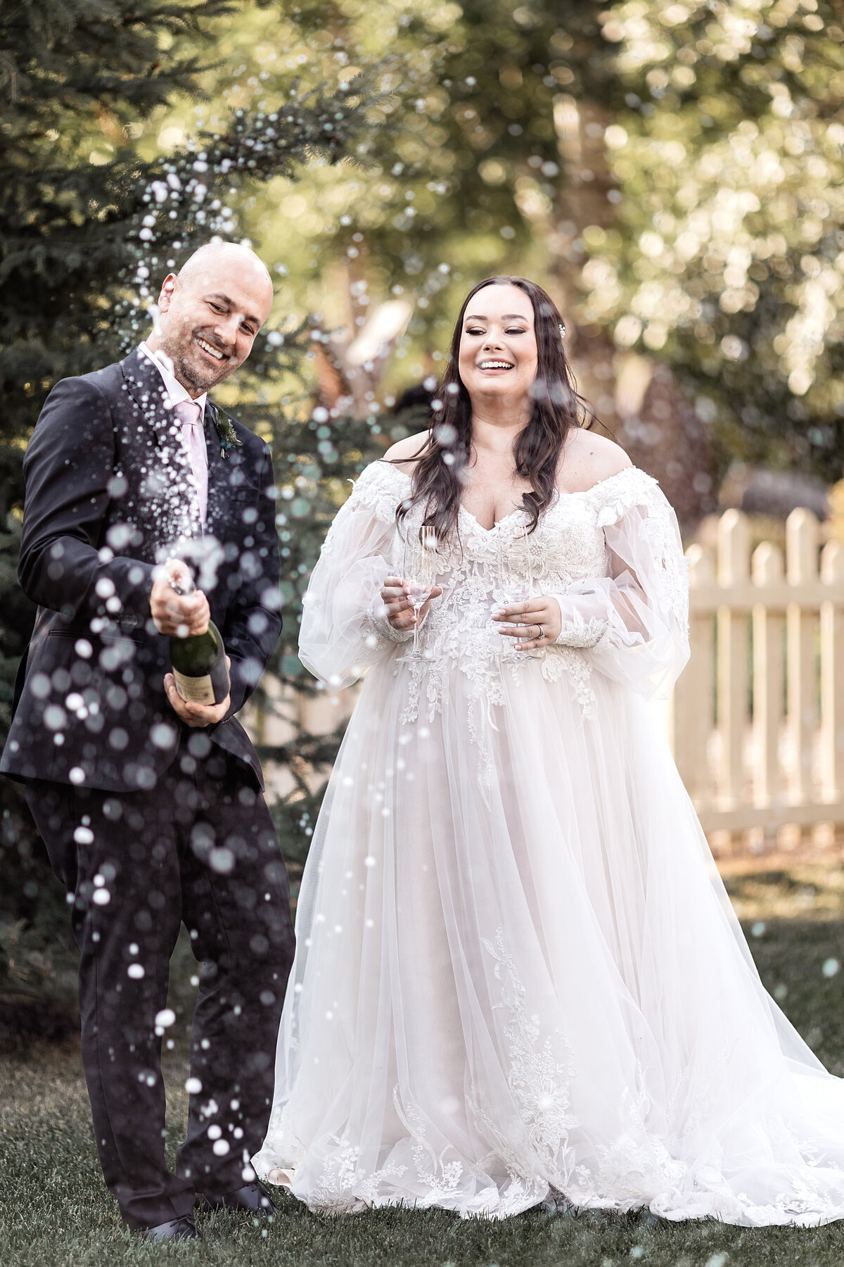 Bride and groom do a champagne pop after their wedding ceremony
