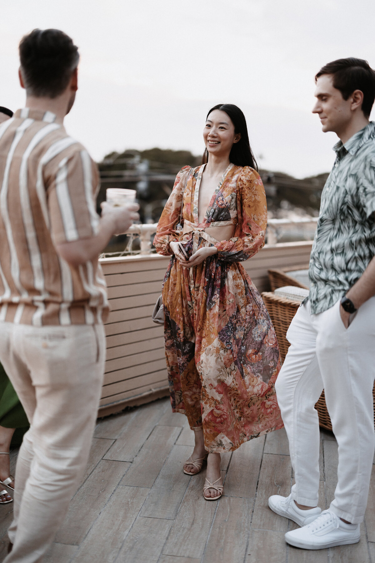 Guests mingling on the deck wearing dress clothes