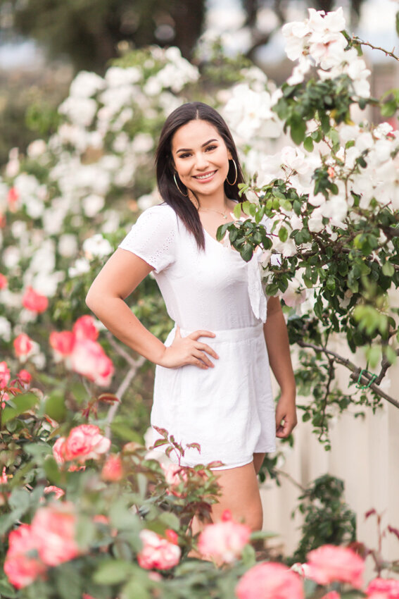 senior girl standing in roses