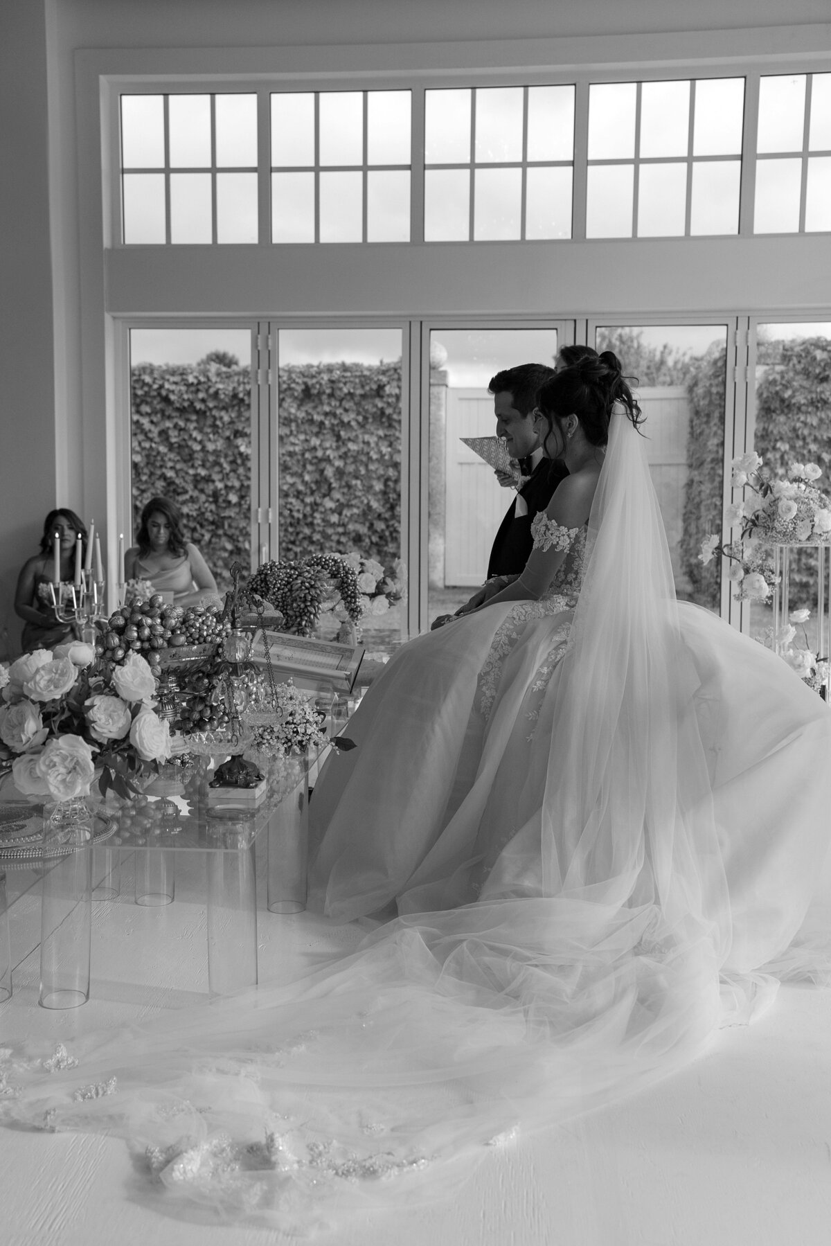 Bride and Groom sit at Sofreh Aghd during Persian wedding ceremony at Belle Mer, Newport.