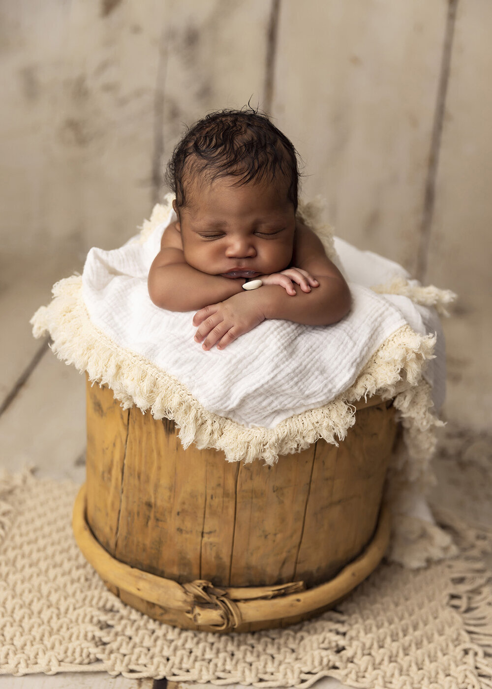 NEWBORN_BABYBOYAFRICANBABYPOSEDINAWOODENBUCKET