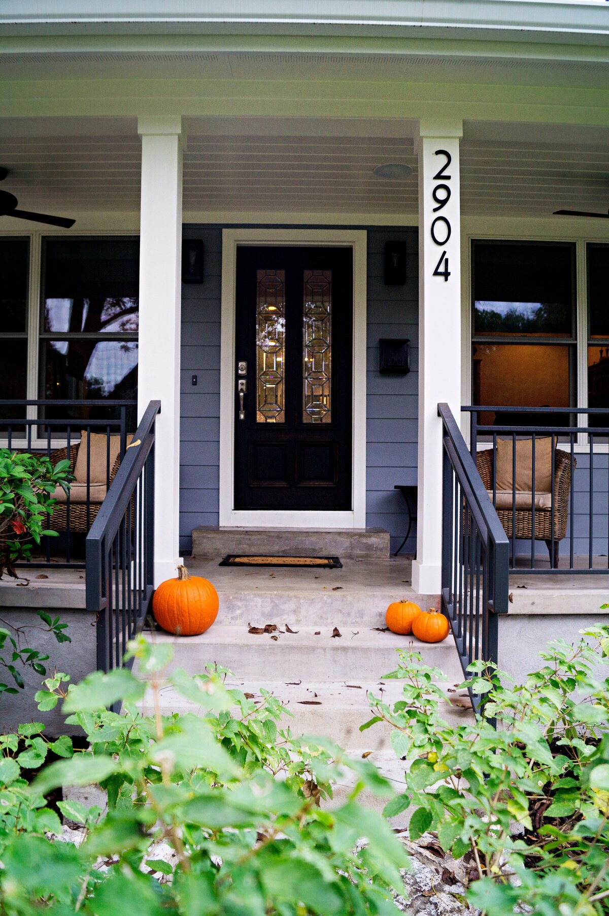 Front porch of family house with halloween pumpkins on steps.