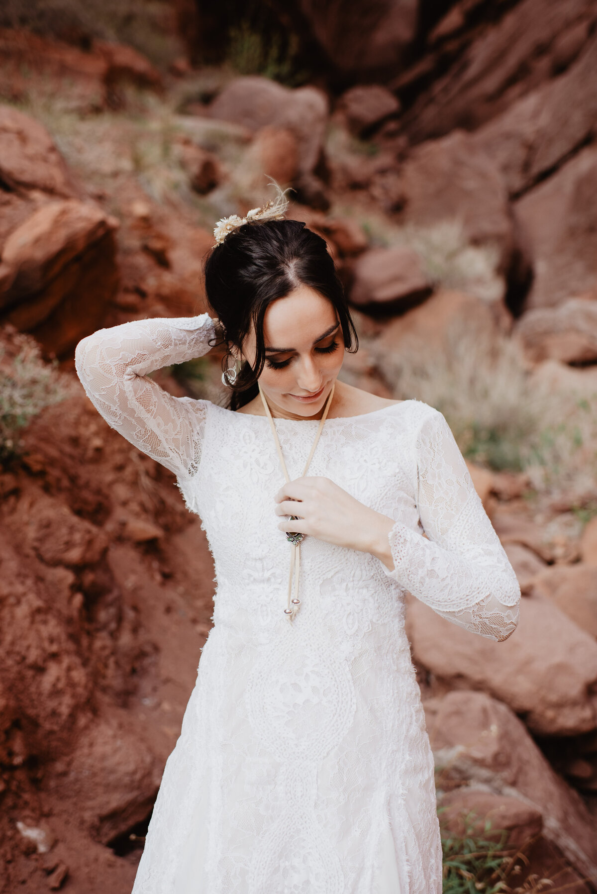 Utah Elopement Photographer captures bride putting on necklace