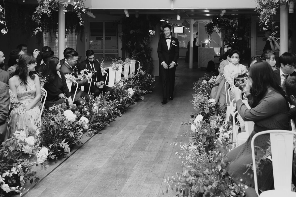 the groom arriving and walking down the aisle