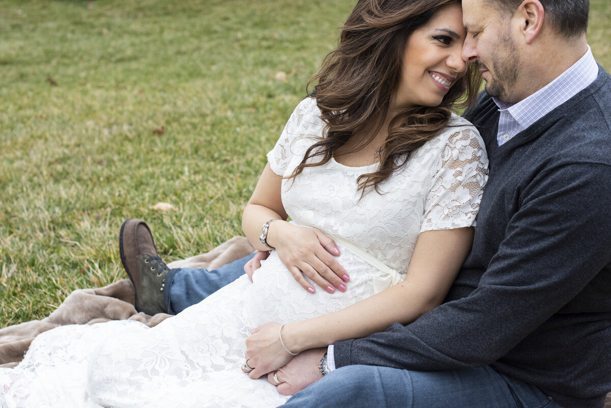 Couple sitting and holding belly The NC Arboretum Asheville NC maternity photography