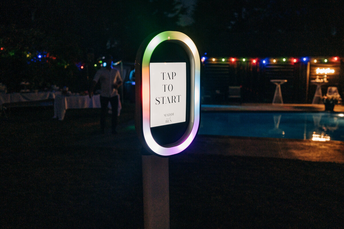 the start screen of a photo booth lit up beside a christchurch swimming pool