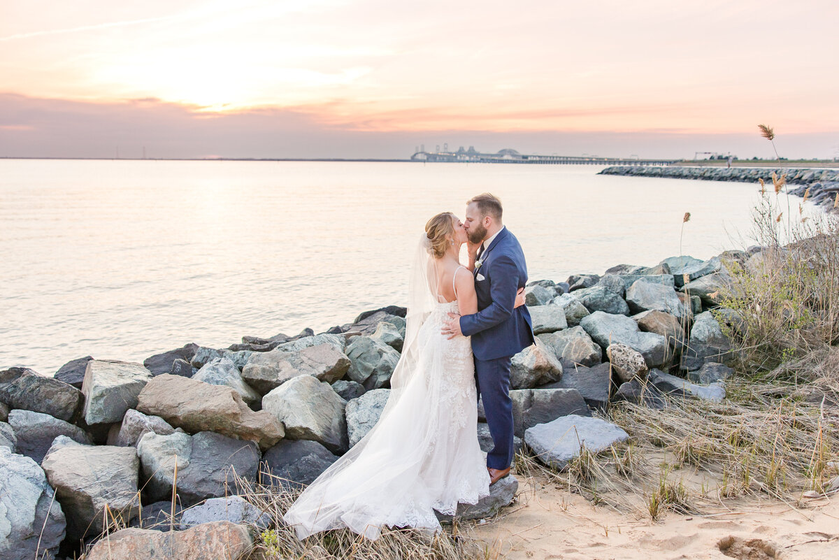 couple kissing at sunset overlooking bay bridge chesapeake bay beach club