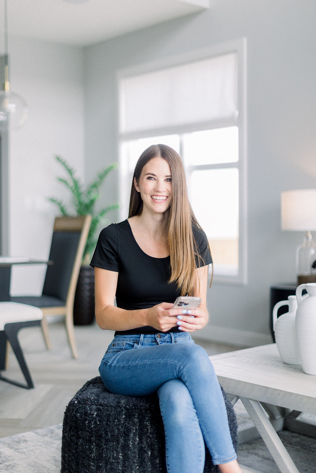 Brand photo of a brunette woman smiling while holding her phone