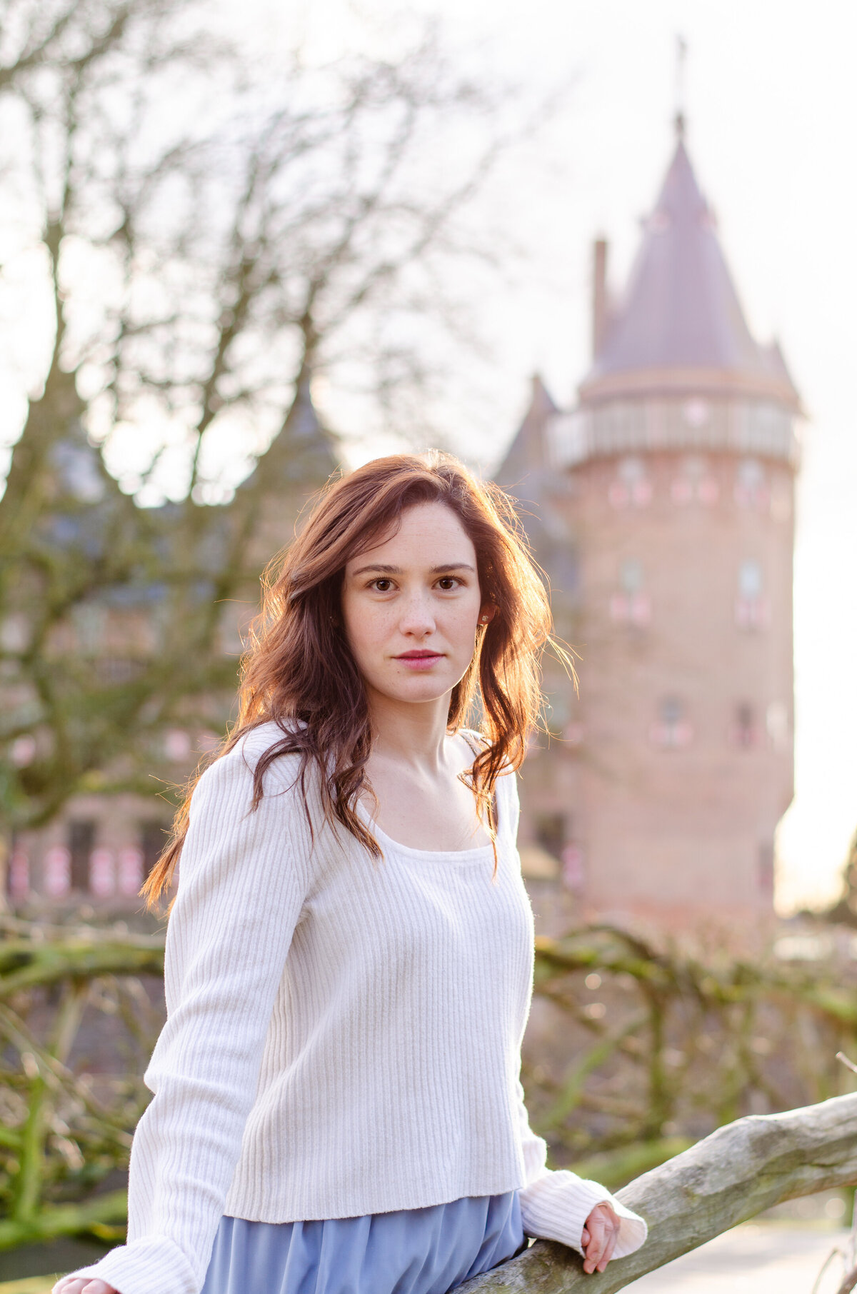 woman on bridge with netherlands castle behind her