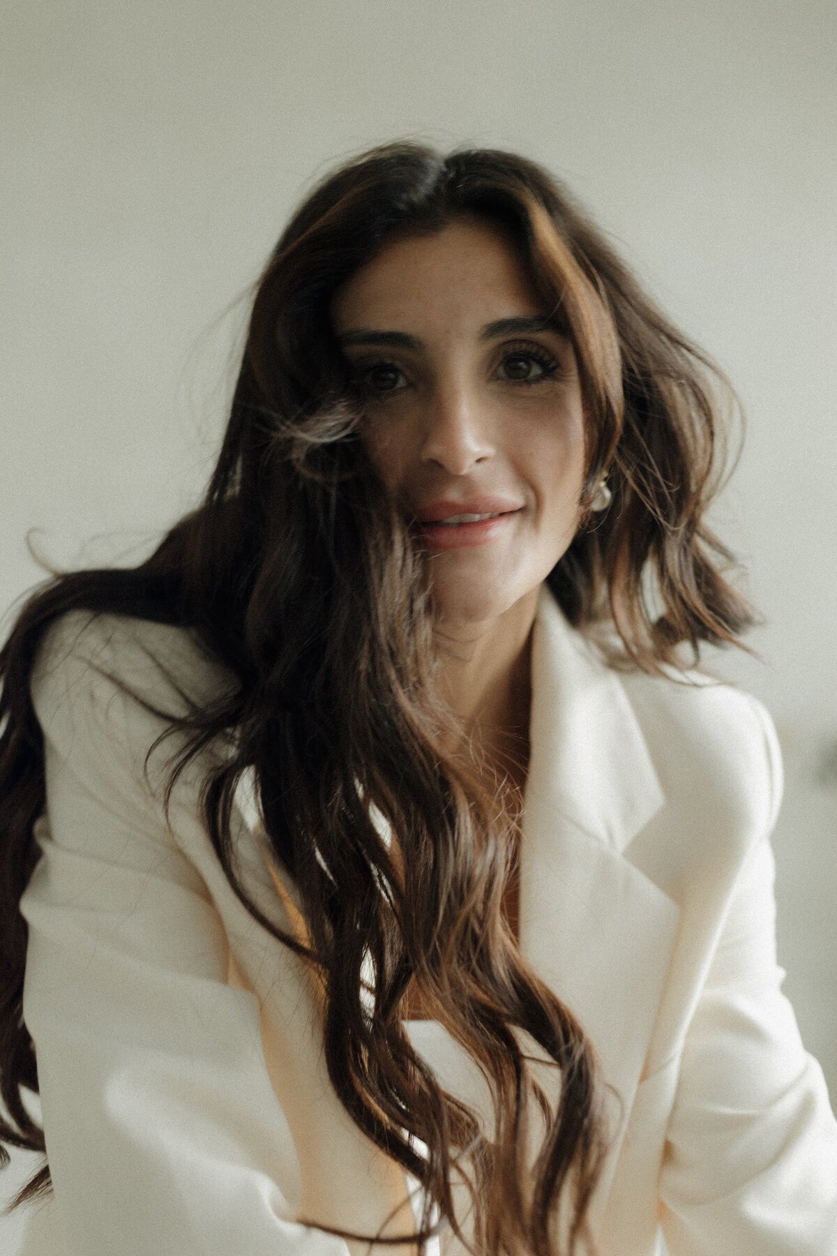 Jiordana smiling in a white blazer