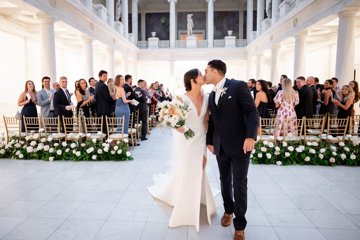 carnegie museum wedding ceremony kissing at end of the aisle in hall of sculpture