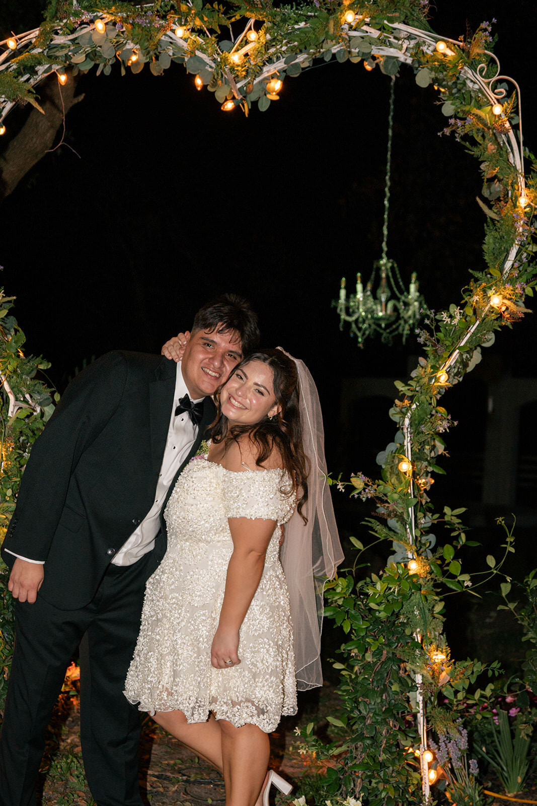 Bride and groom sharing a joyful moment under twinkling lights at Uliana Estate wedding venue in Florida.