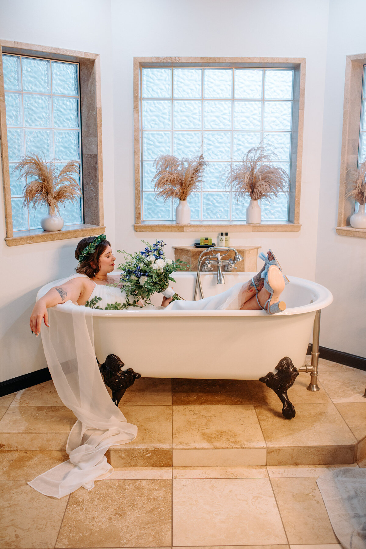 A newlywed sits in a bathtub with a wedding dress on