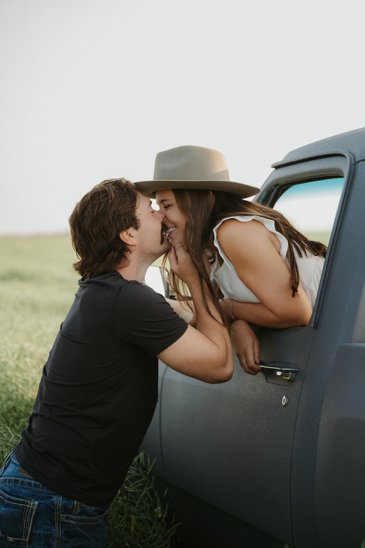 Photo of couple kissing out the window of their old vintage truck in Edmonton Alberta