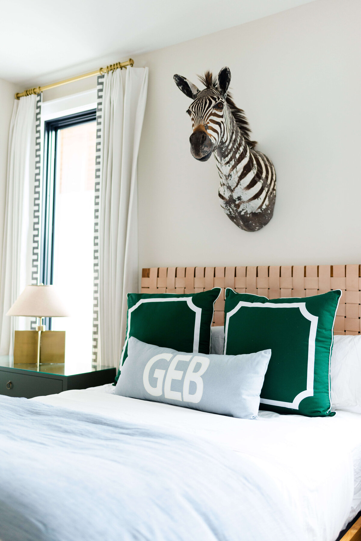 oyster creek studios building belt new build zebra bust over bed with green pillows in bedroom