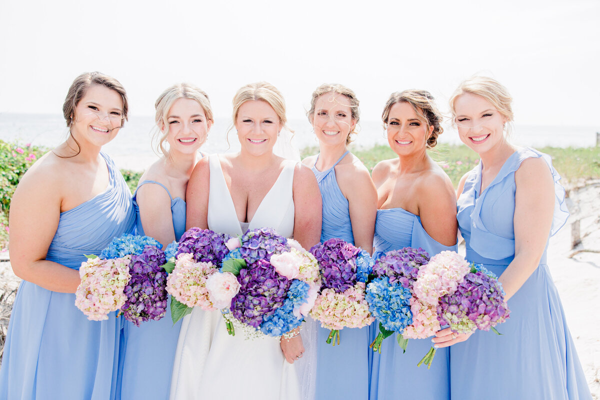 Bride and bridesmaids smiling at the camera representing joyful Cape Cod wedding photography