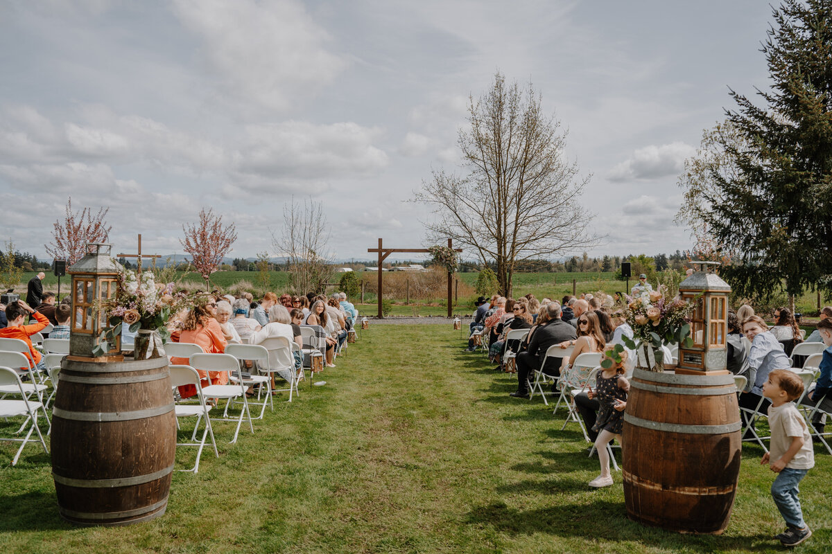 Outdoor wedding ceremony with wine barrel decor