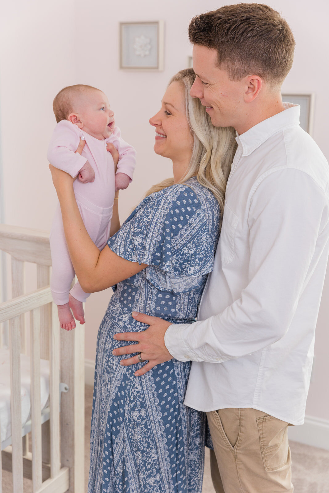 parents standing in the nursery and looking at there newborn baby girl Laure Photography Atlanta family and newborn photographer