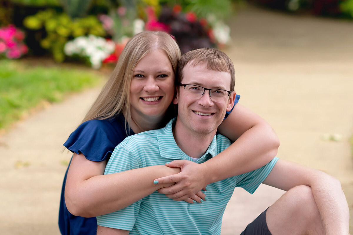 Mom and Dad hug as they sit on a garden path