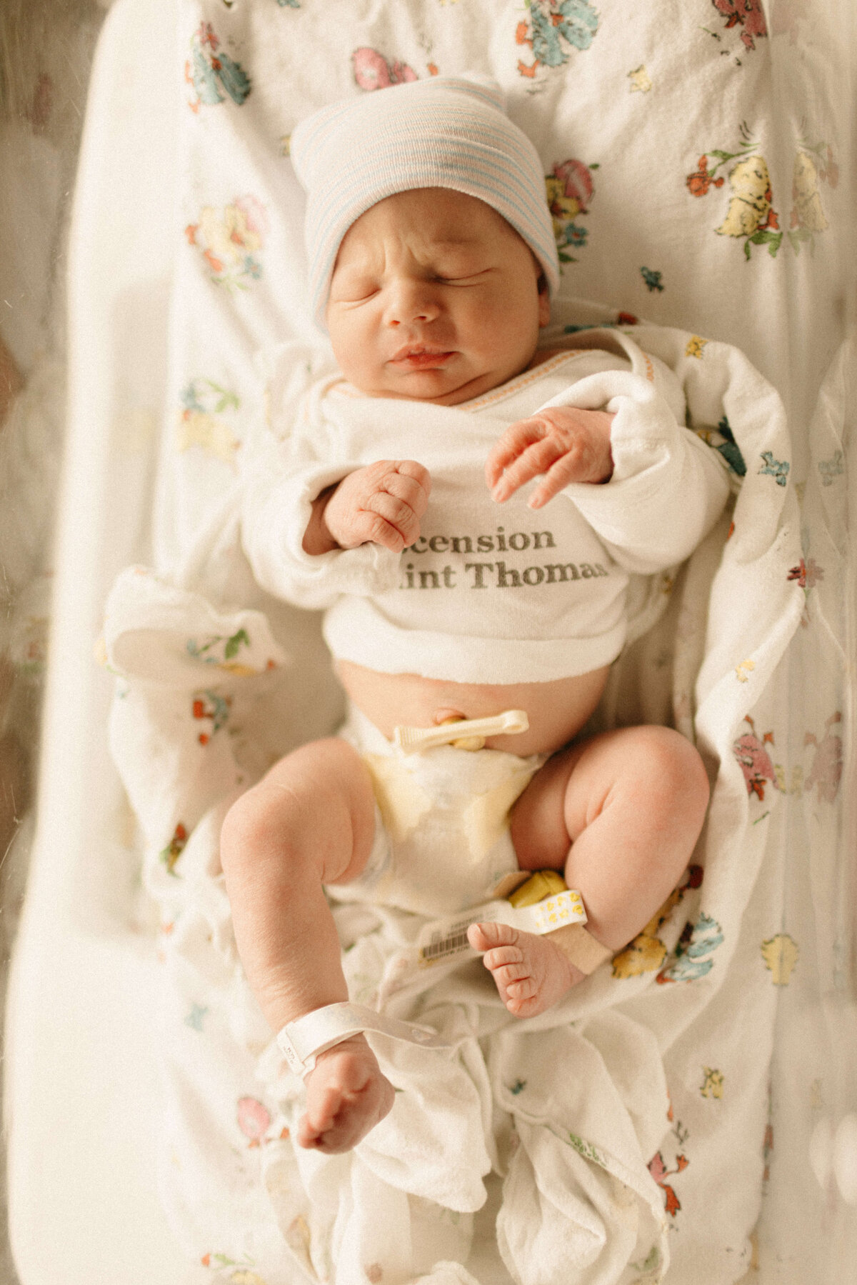 Parents snuggling newborn in hospital bed during Nashville Fresh 48 session.