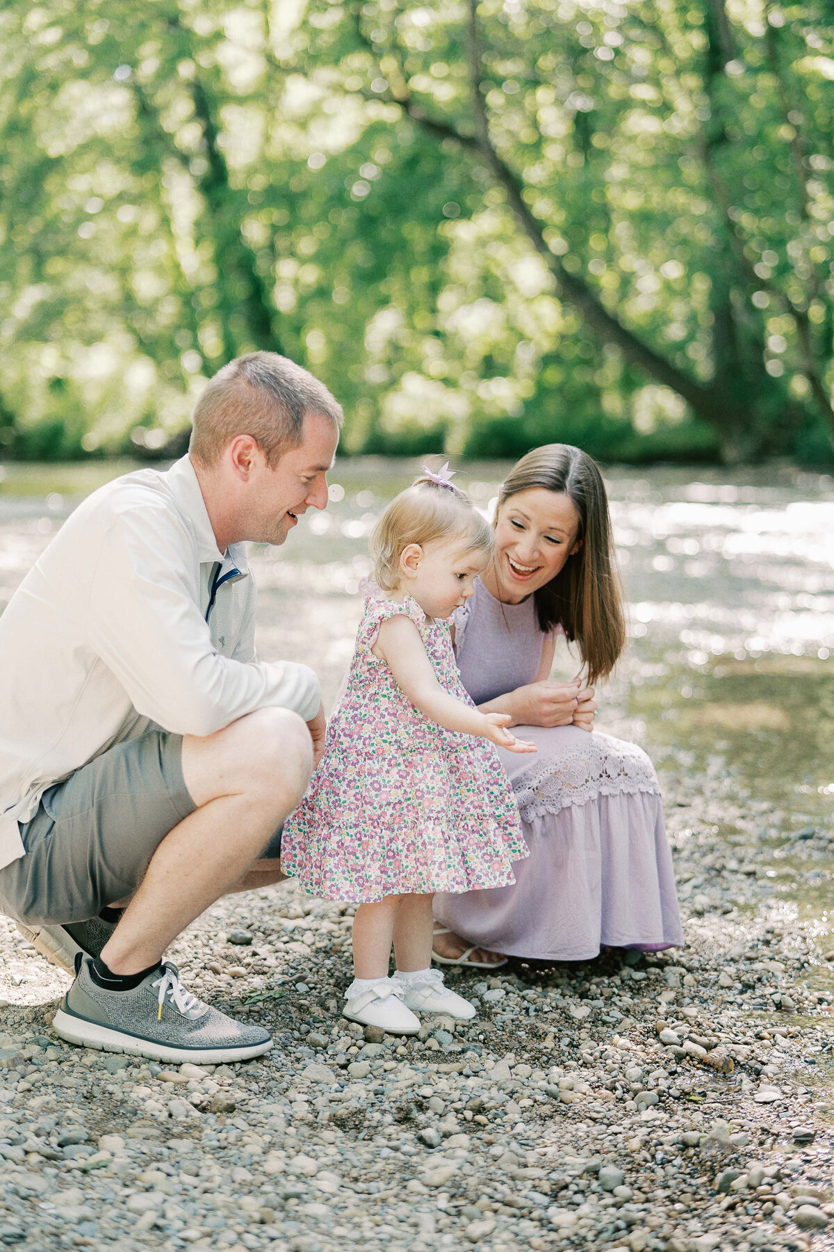 family of three throwing rocks into the creek