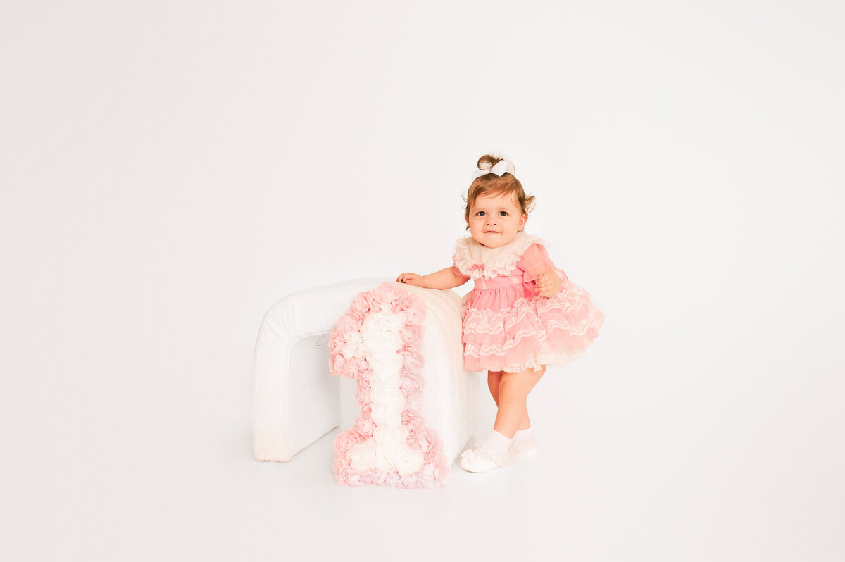 1 year old girl walking in photography studio during Springfield MO milestone and kids photography session