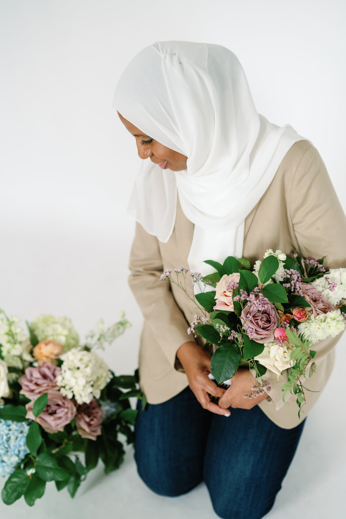 owner, planner, designer holding a beautifully arranged floral bouquet, showcasing artistry and passion for floral design, designed by In Full Bloom Event Planning & Design