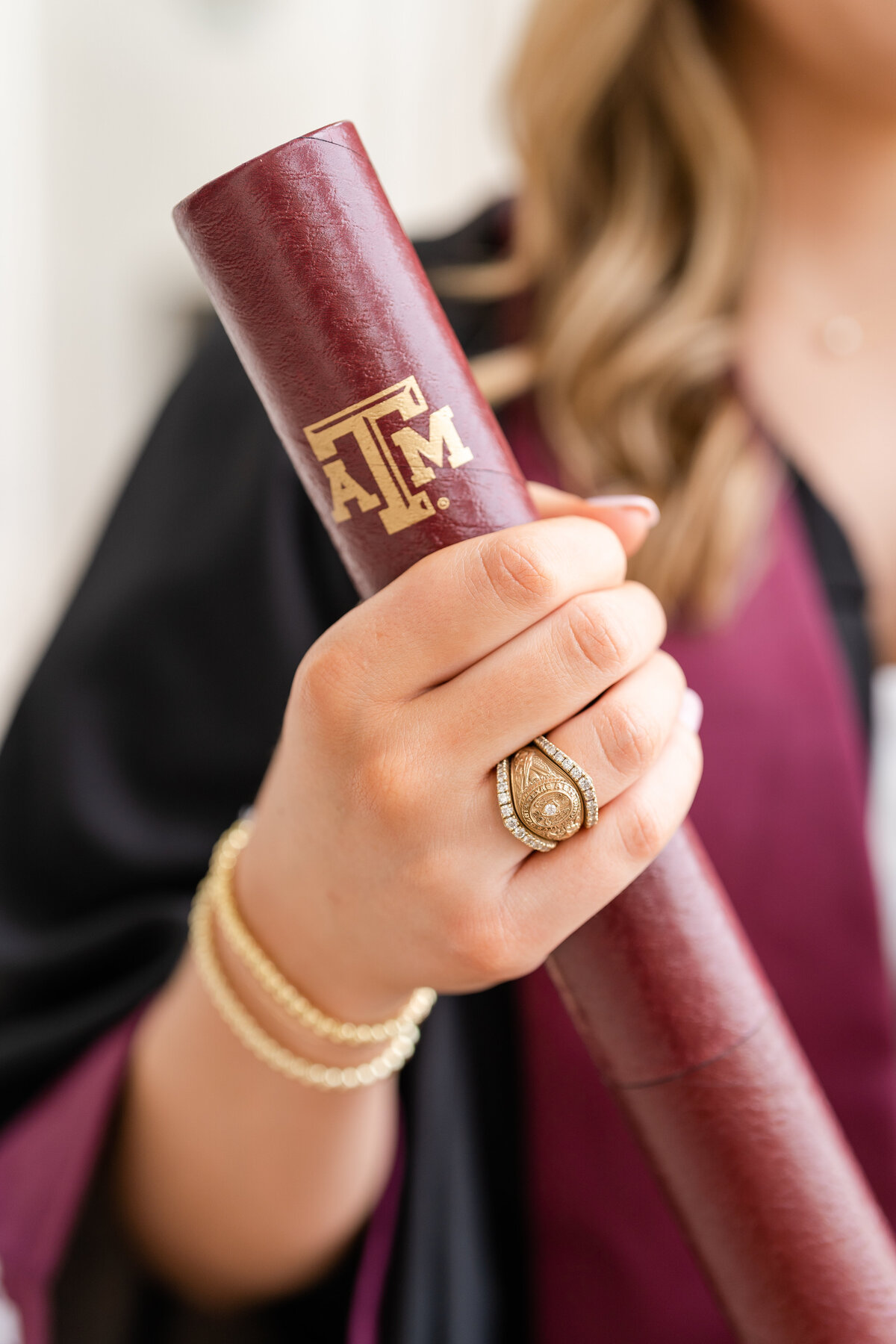 Texas A&M senior girl holding grad diploma holder and close up of Aggie ring with ring wrap