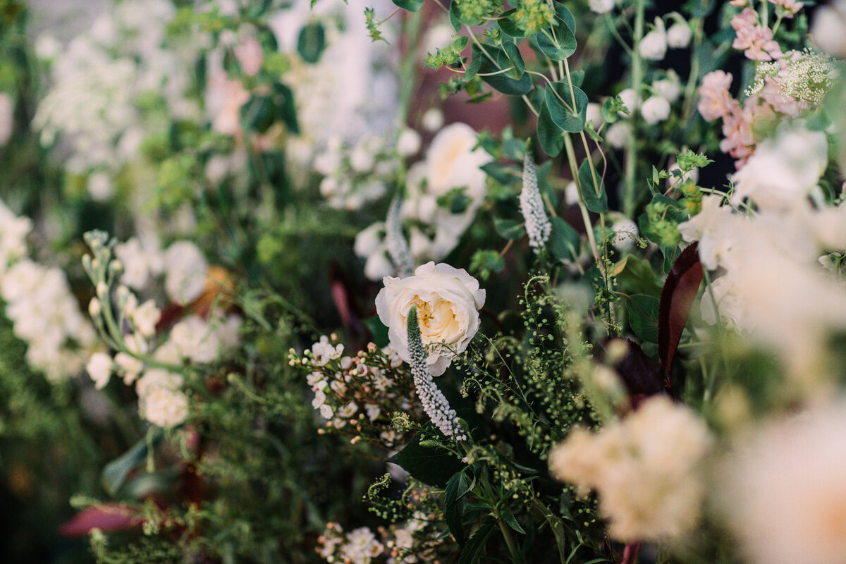 Burgundy hypericum berry, queen anne's lace, peach stock flower, and greenery for wedding ceremony