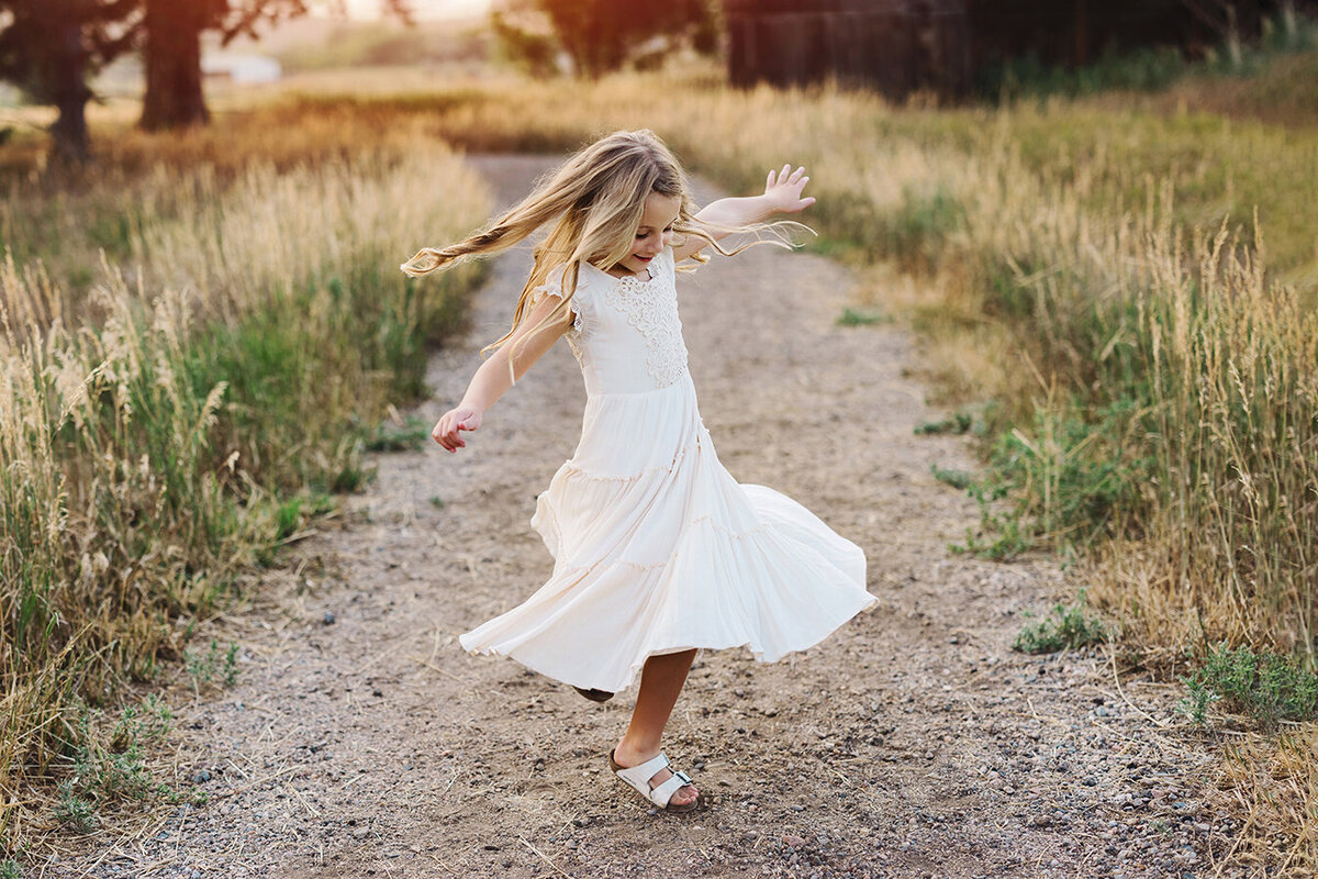 Little girl twirling in a Fort Collins area field