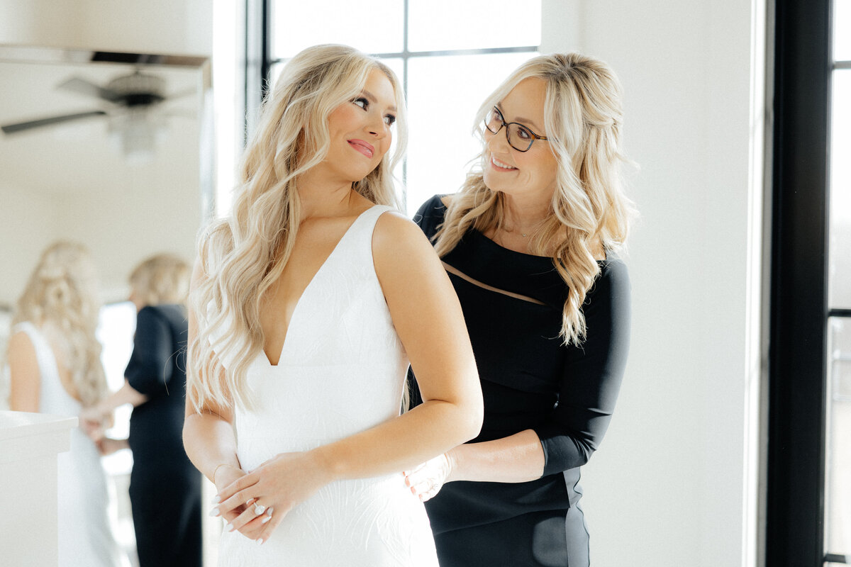 The bride and her mother smiling at each other.