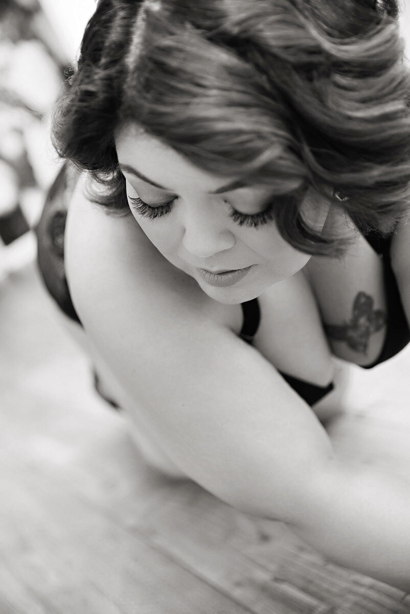 Woman posing on ground for classic b;lack and white boudoir shoot